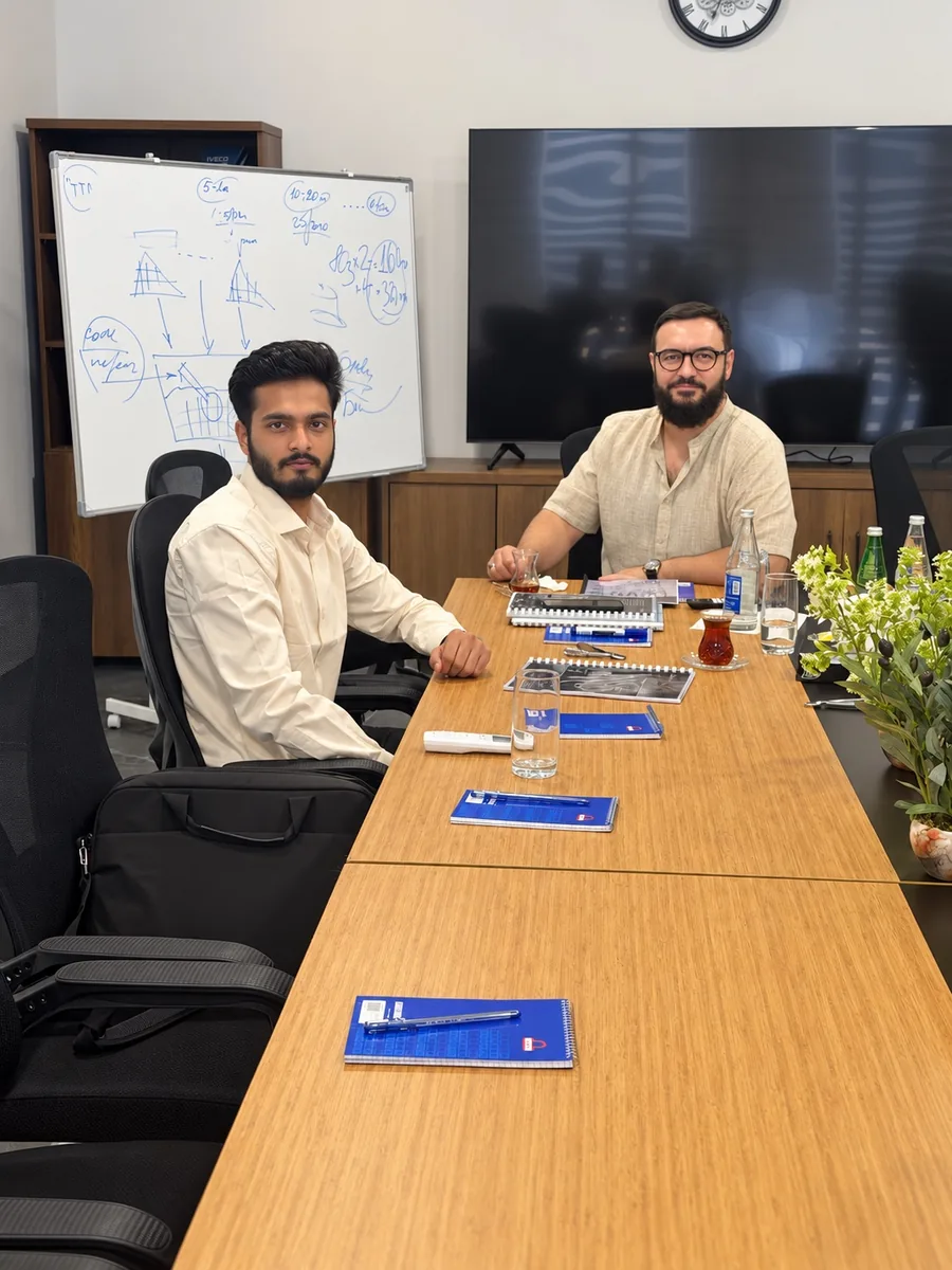 Daim Ali and Dr. Rustam seated across a meeting table in Baku