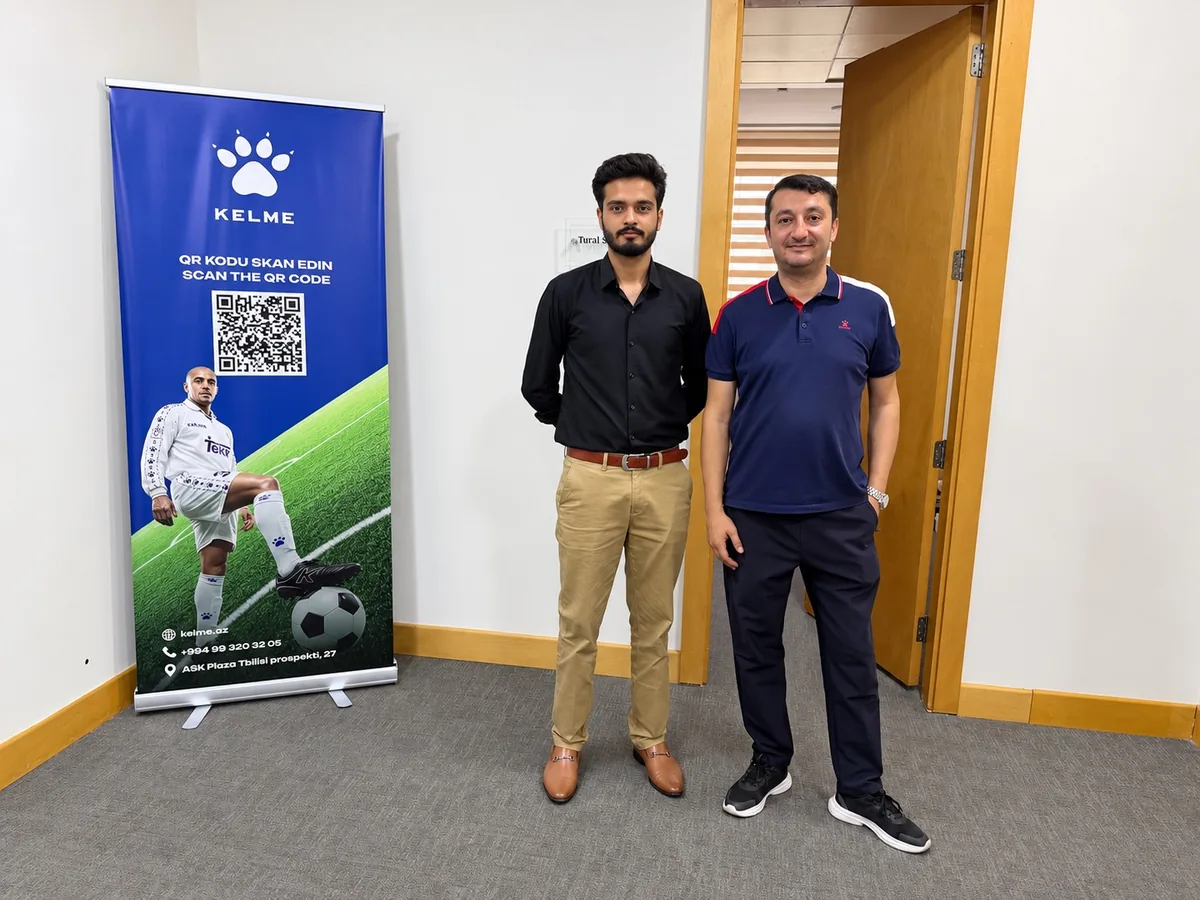 Daim Ali and Mr. Tural beside a KELME Azerbaijan banner in Baku